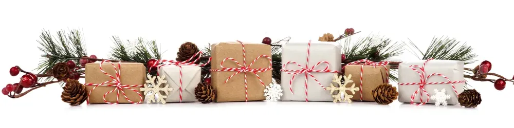 Christmas border with branches and rustic brown and white gift boxes isolated on a white background